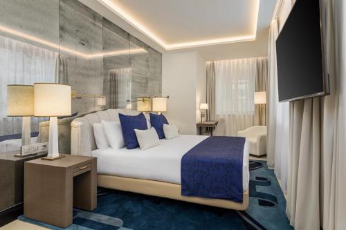 a bedroom with a large bed and a flat screen tv at Room Mate Collection Filippo, Rome-Fontana di Trevi in Rome