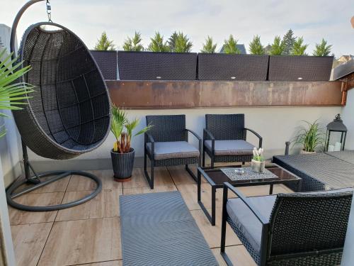 a patio with chairs and tables on a balcony at Wellness Apartmány EMPORIO in Loštice