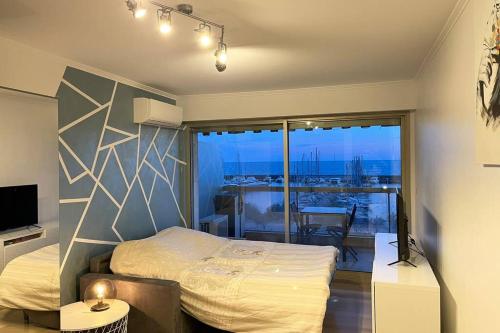 a bedroom with a bed and a balcony with a view at Vue mer port de garavan in Menton