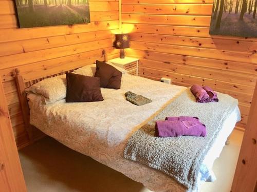 a bedroom with a bed in a wooden wall at 3-Bed Lodge - Sleeps 7 - Hot Tub - Pet Friendly in Skipton