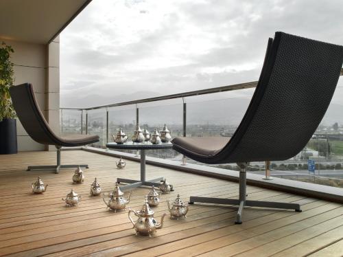 two chairs and a table on a balcony with a view at Hotel Abades Nevada Palace in Granada