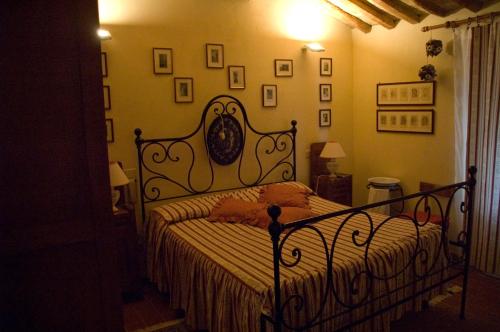 a bedroom with a bed with a wrought iron frame at Agriturismo La Leccia in Bibbona