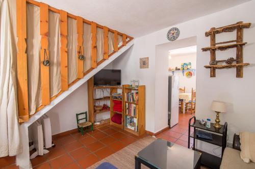 a living room with a staircase and a table at La Casita del Arrabal in Casares
