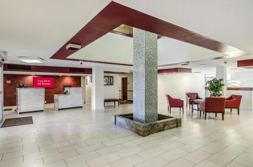 un vestíbulo con mesa, sillas y un pilar en Red Roof Inn PLUS+ Wichita East, en Wichita