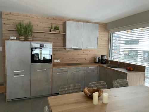 a kitchen with stainless steel appliances and a wooden wall at Familienhaus Kreischberg in Sankt Georgen ob Murau