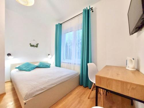Schlafzimmer mit einem Bett, einem Schreibtisch und einem Fenster in der Unterkunft Fajne Miejsce in Łeba