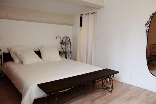 1 dormitorio con cama blanca y espejo en Le Clos du Théron, chambre d'hôte, en Cournonterral