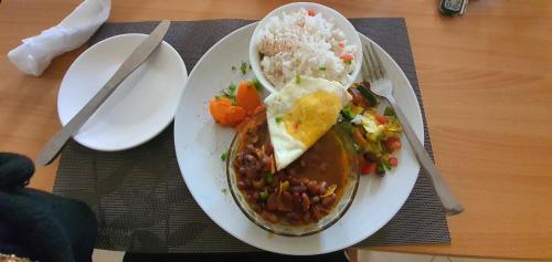 a plate of food with beans and rice on a table at Walabi Mara Hotel in Narok