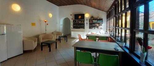 um restaurante com cadeiras verdes e uma sala de jantar em Ciszterci Szállás Pécs em Pécs