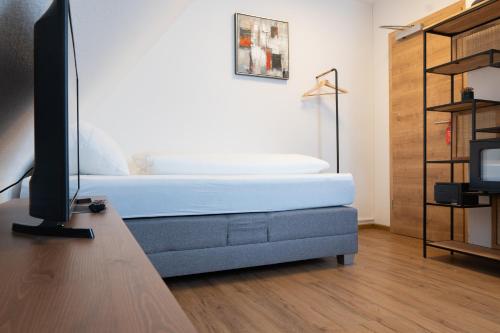 a living room with a bed and a tv at Hotel Dortmunder Hof in Würzburg