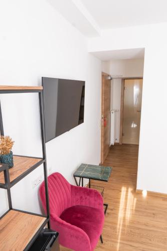 a living room with a red chair and a table at Hotel Dortmunder Hof in Würzburg