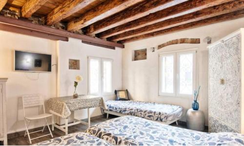 Cette chambre comprend deux lits et une table avec un bureau. dans l'établissement Venice Cadeau, à Venise
