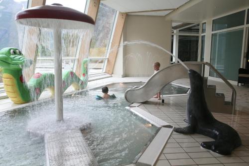 ein Kind in einem Pool mit Springbrunnen in der Unterkunft Hotel Union Geiranger Bad & Spa in Geiranger