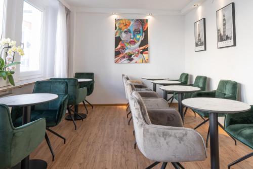 a waiting room with tables and green chairs at Hotel Dortmunder Hof in Würzburg