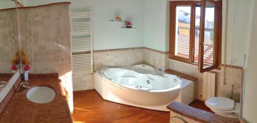 a large bathroom with a tub and a toilet at Mazzini Affittacamere in Viareggio