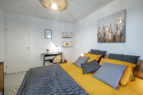 - une chambre avec un lit doté d'oreillers jaunes et bleus dans l'établissement Voltaire, à Toulouse