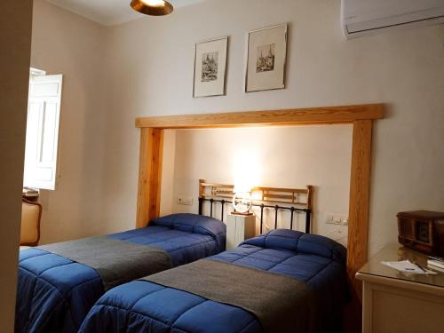 2 camas en una habitación con sábanas azules en La Casa De Las Bicicletas en Cazorla