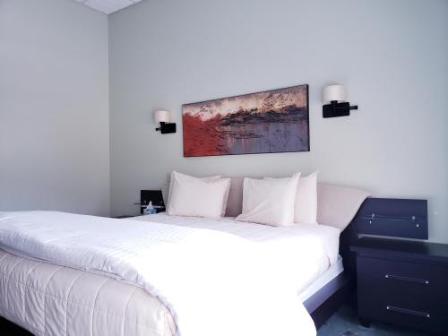 a bedroom with a white bed and a painting on the wall at Lowell Inn in Stillwater