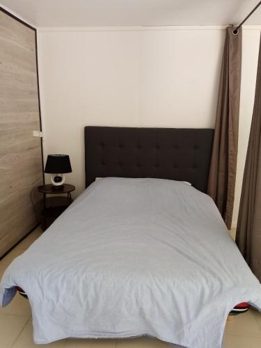 - une chambre avec un lit blanc et une tête de lit noire dans l'établissement Chez Sylvie et Amador, à Las Illas