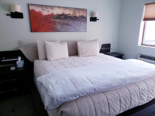 a bedroom with a large bed with white sheets and pillows at Lowell Inn in Stillwater