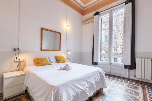 een slaapkamer met een groot wit bed en een raam bij My Address in Barcelona in Barcelona