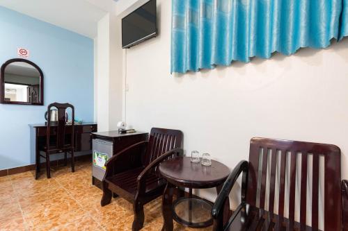 a room with two chairs and a table and a television at Thanh Lan Hotel in Ho Chi Minh City