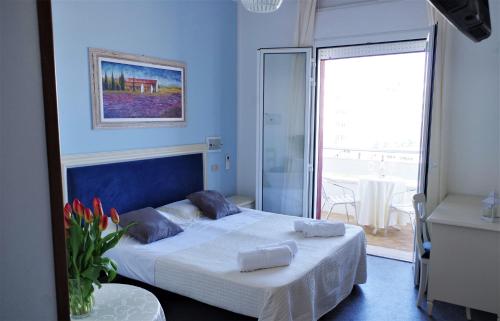 a bedroom with a large bed and a balcony at Golf & Beach Hotel B&B in Milano Marittima