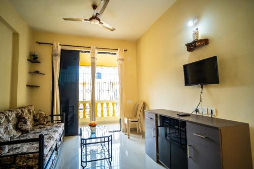a living room with a couch and a flat screen tv at Field stone Apartment in Varca