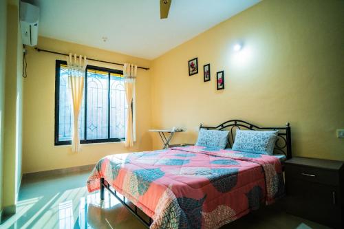 a bedroom with a bed with a colorful blanket and a window at Field stone Apartment in Varca