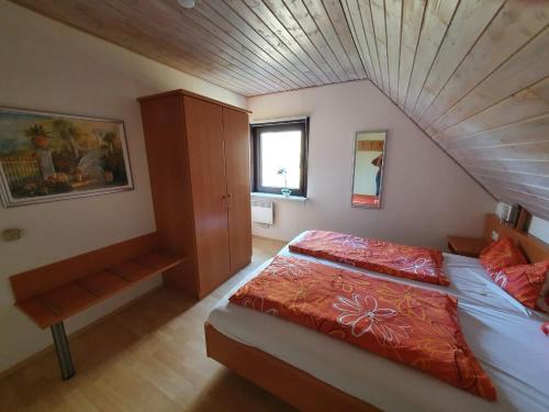 een slaapkamer met een bed en een houten plafond bij Silbersee90 in Frielendorf