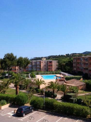 une vue d'une piscine depuis un parking dans l'établissement Studio cosy avec vue sur la mer à Bormes-les-Mimosas, 20 m²., à Bormes-les-Mimosas