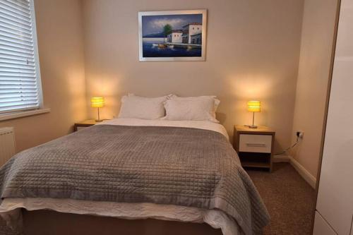 a bedroom with a bed and two lamps on tables at Peninsula Pad in Portrush