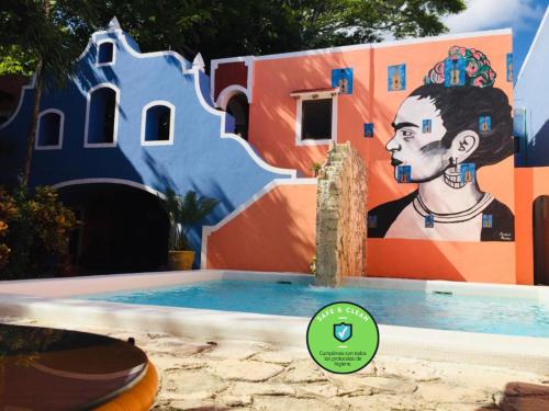 Un edificio con un dipinto di un uomo accanto a una piscina di Hotel Casa de las Flores a Playa del Carmen