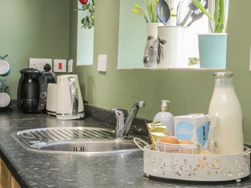 a kitchen counter with a sink and a dishrack of food at 1 Royal Oak Cottages in Shrewsbury