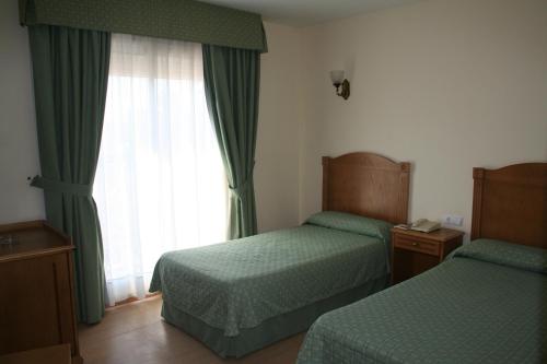 a hotel room with two beds and a window at Hotel Austria 76 in Puerto de Sagunto