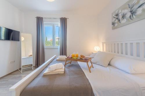 - une chambre blanche avec un lit et une table dans l'établissement Villa Tara, à Tinj