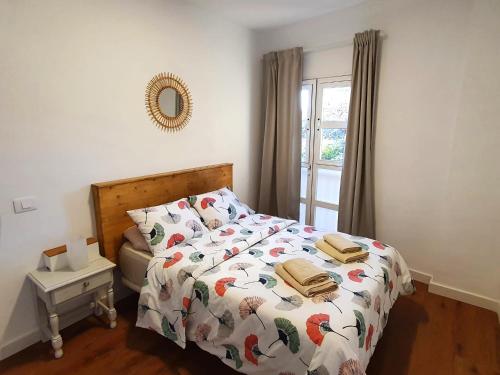 um quarto com uma cama com um edredão e uma janela em La Pardela em Valle Gran Rey
