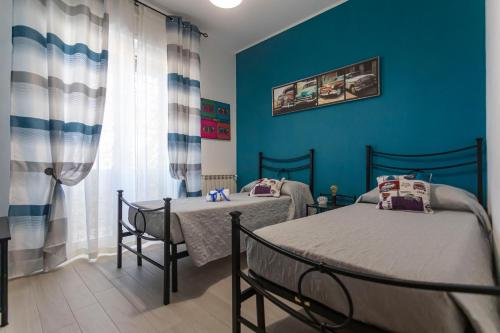 2 camas en una habitación con paredes azules en Casa Vacanze Aurora en Fiumicino