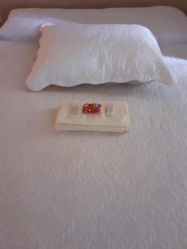 a tray on top of a white bed with a pillow at loft harmonia in Blumenau
