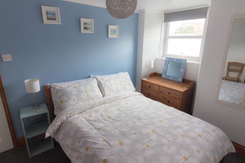 a bedroom with a bed and a television in it at Utopia Apartments in Perranporth