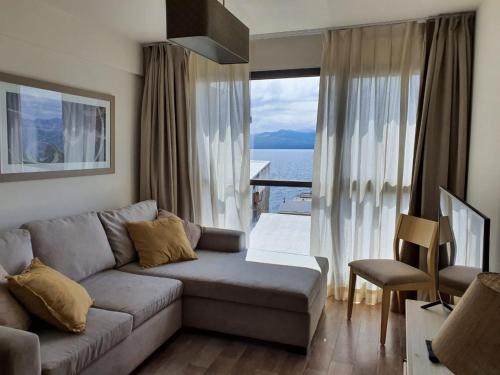 a living room with a couch and a large window at URBANA SUITES & STUDIOS 440 in San Carlos de Bariloche