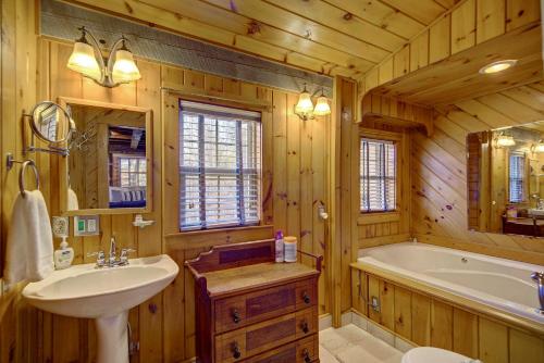 a bathroom with a tub and a sink and a tub and a bath tub at Cozy Log Cabin 6 Mi to Great Smoky Mtns NP! in Townsend