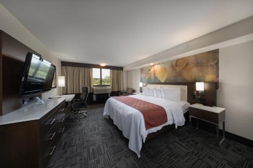 a hotel room with a bed and a flat screen tv at Holiday Inn Brookfield - Milwaukee by IHG in Brookfield