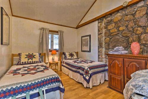 a bedroom with two beds and a stone wall at Screened Porch The Rock Cottage in Hot Springs in Hot Springs