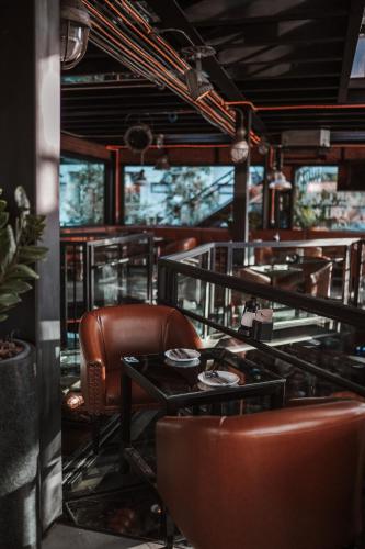 a restaurant with brown leather chairs and tables at Letana Hotel in Bang Phli
