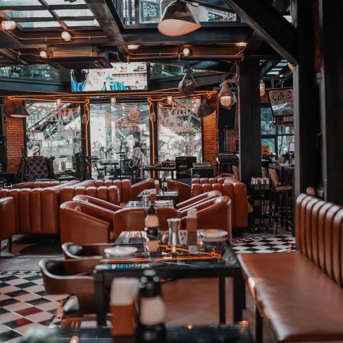 a restaurant with leather chairs and tables and a checkered floor at Letana Hotel in Bang Phli