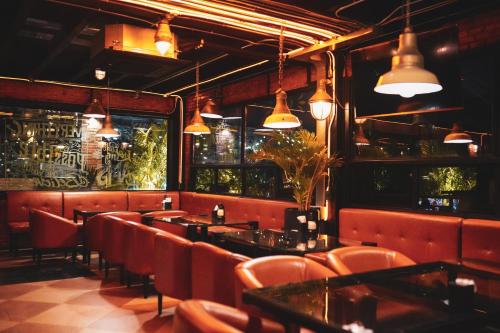 a restaurant with tables and chairs and lights at Letana Hotel in Bang Phli