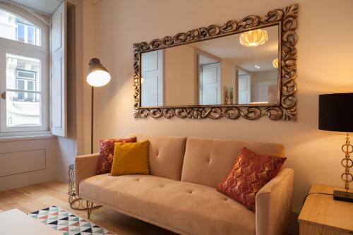 - un salon avec un canapé et un miroir dans l'établissement FLH Downtown Classic Luxus Apartment, à Lisbonne