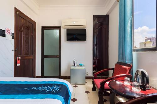 a room with a bed and a table and a chair at Thanh Lan Hotel in Ho Chi Minh City