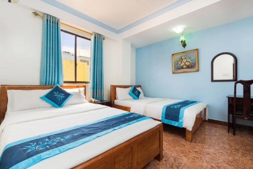 a bedroom with two beds and a window at Thanh Lan Hotel in Ho Chi Minh City